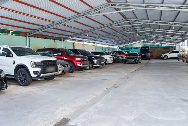 Dãy xe SUV, bán tải đỗ dưới mái che dài, nền bê tông tại bãi xe Dũng Lợi